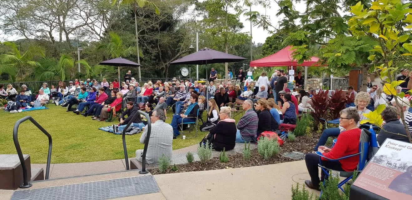 Crowd enjoying an outdoor concert in a Palmwoods garden